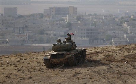 Turecký voják na turecko-syrských hranicích. V pozadí hraniní msto Kobani.