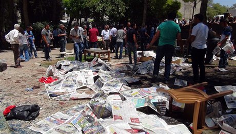 Na místě exploze zakrývají těla obětí noviny.