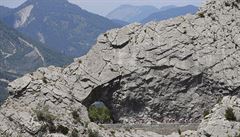 Peloton projídí skalním tunelem v srdci francouzských Alp.