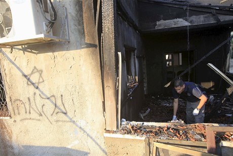 Izraeltí policisté zkoumají trosky podpálených dom.