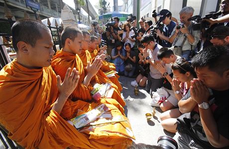 Buddhistití mnii se modlí poblí místa pondlního výbuchu.