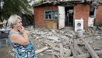 Žena stojí před svým domem na předměstí Doněcku. Její dům byl zničen při...