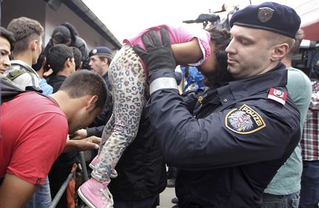 Nádraí Nickelsdorf: Policista vytahuje z davu uprchlík malou holiku, aby...