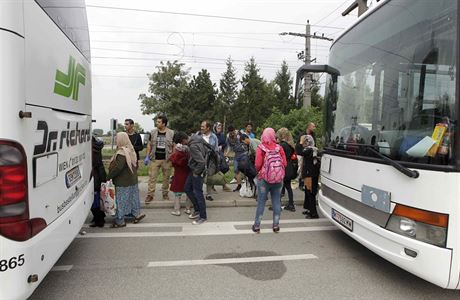 Uprchlci vystupuj z autobus u ndra Nickelsdorf.