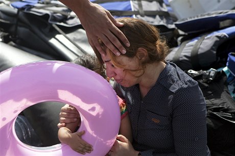 Úleva i vyčerpání. Syrská matka s dcerkou v náručí těsně po vylodění na řeckém...