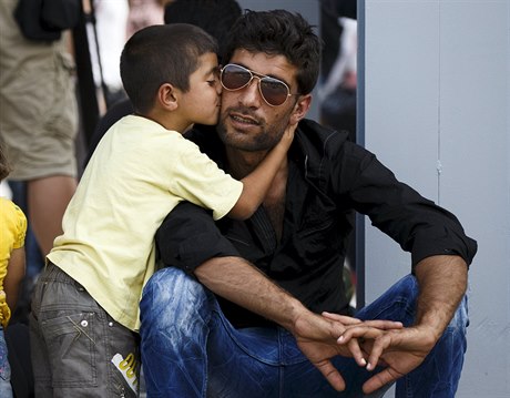 Chlapec pvodem ze syrského msta Kobani líbí svého otce poté, co bezpen...