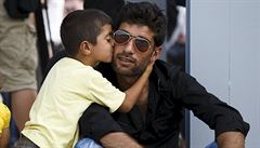 Chlapec pvodem ze syrského msta Kobani líbí svého otce poté, co bezpen...