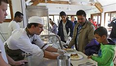 Uprchlíci ze Sýrie a Iráku dostávají jídlo po píchodu do sgtediska Hubert...