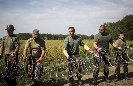 Maďarští vojáci natahují žiletkový drát podél hranice s Chorvatskem.