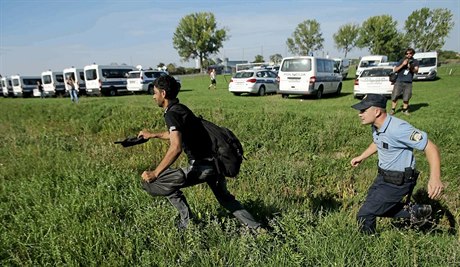 Chorvatský policista se snaží poblíž Tovarniku dostihnout migranta, který do...