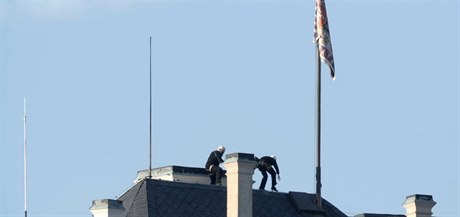 Aktivisté, pevleení za kominíky lezou po stee Praského hradu, aby...