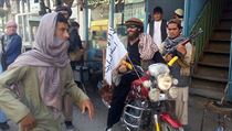 Bojovnk Talibanu na motocyklu s vlajkou radiklnho hnut ve mst Kunduz.
