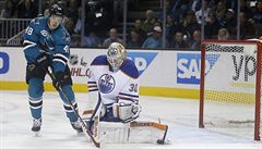 Tomá Hertl ze San Jose teuje puk ped brankáem Edmontonu Benem Scrivensem.