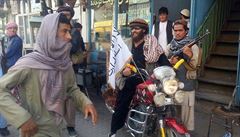 Bojovník Talibanu na motocyklu s vlajkou radikálního hnutí ve mst Kunduz.