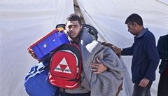 Uprchlík si nese zavazadla do svého stanu.