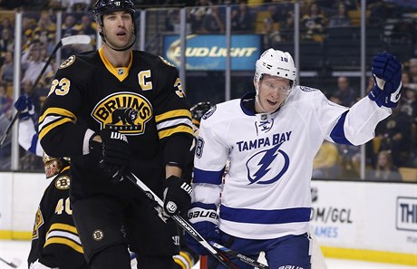 Hrá Tampa Bay Ondej Palát (18) vedle Zdena Cháry (Boston Bruins) se raduje z...