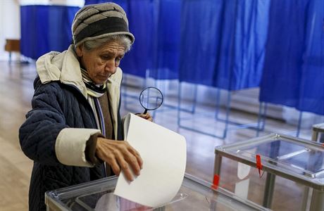 ena hází do urny volební lístek ve volební místnosti v Kyjev.