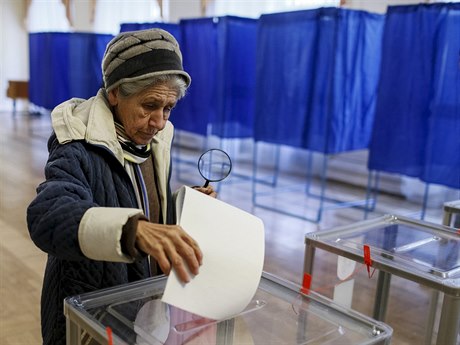 ena hází do urny volební lístek ve volební místnosti v Kyjev.