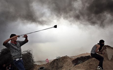 Náctiletí Palestinci hazí kameny na Izraelce