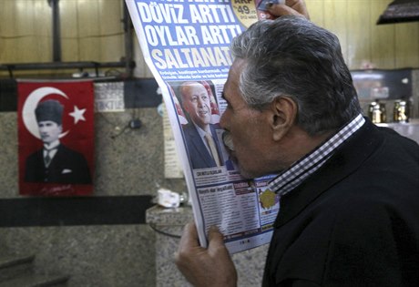 Muž líbá portrét prezidenta Erdogana v novinách.