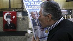 Mu líbá portrét prezidenta Erdogana v novinách.
