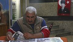 Mu si v istanbulské kavárn prochází nejnovjí vydání novin vnované volebním...
