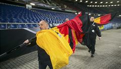Tak dnes ádné fandní. Poádková sluba odnáí ze stadionu v Hannoveru vlajky...
