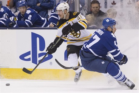 Útoník Boston Bruins David Krejí (vlevo), bere puk hrái Toronto Maple Leafs...