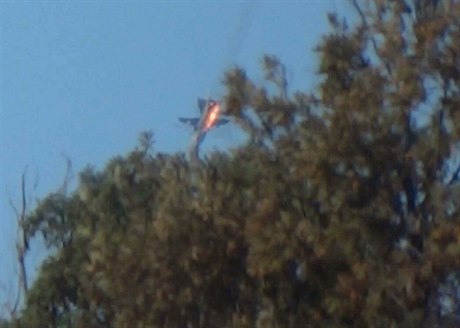 Ruský letoun Su-24 se ítí v plamenech k zemi (snímek z videozáznamu).