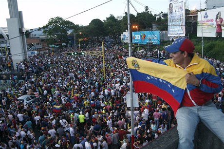 Stoupenec venezuelské opozice se státní vlajkou na pouliním shromádní k...