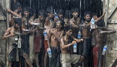 Migranti chytající pitnou vodu bhem det v uprchlickém táboe Kanyin Chaung...