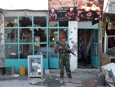 Afghánský voják ped obchodem vypálených bhem útoku Talibanu na kandahárské...