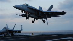 Letoun F/A-18 Super Hornet pistává. Vysunutým hákem musí zachytit jedno z...