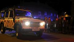 Evakuovaní obyvatelé sledují zásah záchraná u zíceného mostu v Tedcasteru.