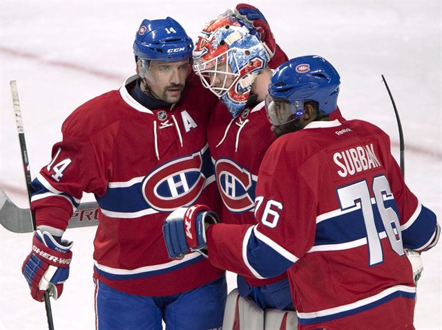 Branká Montreal Canadiens Mike Condon se spoluhrái Tomáem Plekancem (vlevo)...