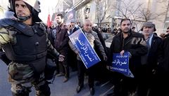 Íránský policista a demonstranti ped ambasádou Saúdské Arábie v Teheránu.