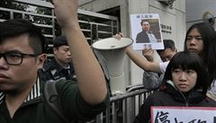 Demonstranti s fotkou poheovaného knihkupce Li Poa protestují v Hongkongu....