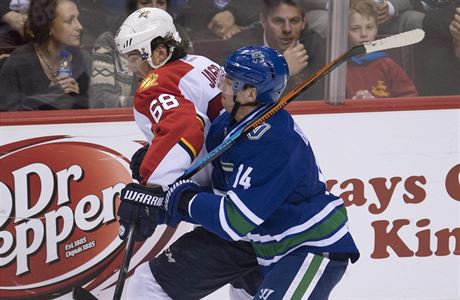 tonk Vancouver Canucks Alex Burrows (14) v souboji s Jaromrem Jgrem (68).