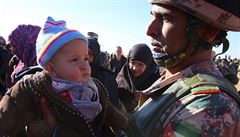 Jordánský voják se syrským kojencem v uprchlickém táboe pro syrské bence.