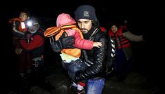 Afghánský migrant pomáhá dítti pi vylodní na eckém ostrov Chios.