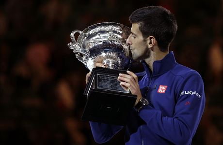 Novak Djokovic of Serbia kisses his trophy aloft after defeating Andy Murray of...