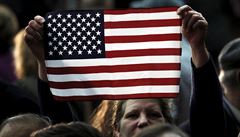 Stoupenkyn Donalda Trumpa drí americkou vlajku na pedvolebním mítinku v...