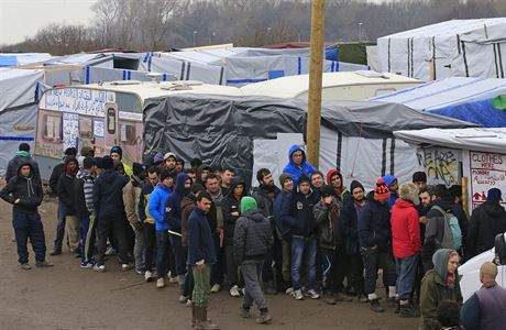 Migranti v tboe v Calais stoj frontu na distribuovan obleen.