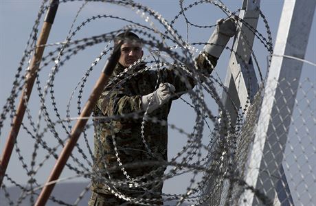Makedonský voják instaluje plot z ostnatého drátu.