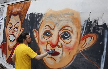 Pouliční umělec sprejuje na zeď karikatury Luly da Silvy a Rousseffové během...