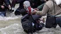 Migrant zachrauje dt ped pdem do vody, zatmco se migranti prodraj ekou...