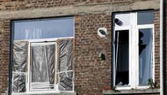Rozbitá okna domu na bruselském pedmstí.