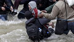Migrant zachrauje dít ped pádem do vody, zatímco se migranti prodírají ekou...