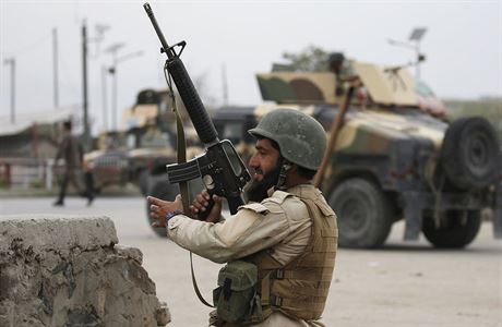 Voják afghánské armády zaujímá pozici po sebevražedném atentátu v Kábulu.