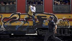 Jeden z uprchlík se snaí vylézt do vlaku.
